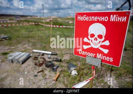 Hostomel, Ucraina. 25th luglio 2022. Sul terreno dell'aeroporto Antonov è un'area di addestramento per la rimozione di mine e ordigni esplosivi. Sul bordo c'è un cartello di avvertimento con l'iscrizione 'Danger Mines'. Credit: Christophe Gateau/dpa/Alamy Live News Foto Stock