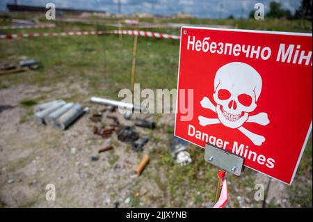 Hostomel, Ucraina. 25th luglio 2022. Sul terreno dell'aeroporto Antonov è un'area di addestramento per la rimozione di mine e ordigni esplosivi. Sul bordo c'è un cartello di avvertimento con l'iscrizione 'Danger Mines'. Credit: Christophe Gateau/dpa/Alamy Live News Foto Stock