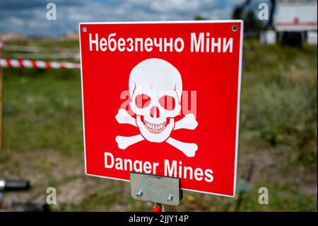 Hostomel, Ucraina. 25th luglio 2022. Sul terreno dell'aeroporto Antonov è un'area di addestramento per la rimozione di mine e ordigni esplosivi. Sul bordo c'è un cartello di avvertimento con l'iscrizione 'Danger Mines'. Credit: Christophe Gateau/dpa/Alamy Live News Foto Stock