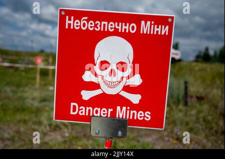 Hostomel, Ucraina. 25th luglio 2022. Sul terreno dell'aeroporto Antonov è un'area di addestramento per la rimozione di mine e ordigni esplosivi. Sul bordo c'è un cartello di avvertimento con l'iscrizione 'Danger Mines'. Credit: Christophe Gateau/dpa/Alamy Live News Foto Stock