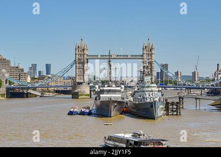 Londra, Inghilterra - Giugno 2022: HMS Belfast e una moderna nave da guerra Royal Navy ormeggiata sul Tamigi. Sullo sfondo si trova il Tower Bridge. Foto Stock