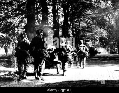 Ritish Airbourne Forces in Holland -- uomini del secondo atterraggio di Airbourne che si miving in avanti in Arnhem con le loro armi e attrezzature. Quando il 1st., Allied il 1st. L'esercito di Allied Airbourne è stato abbandonato in Olanda, con i fotografi dell'Army Film and Photographic Unit. Questa è una delle prime fotografie ricevute da loro. Uno dei fotografi scrive in una lettera datata 20th settembre., 'questo è il quarto giorno se combattere un lavoro della macchina fotografica è quasi della domanda. Tutto il giorno siamo stati sotto la conchiglia, mortaio e mitragliatrice. Dicembre 04, 1944. (Foto della fotografia ufficiale britannica). Foto Stock