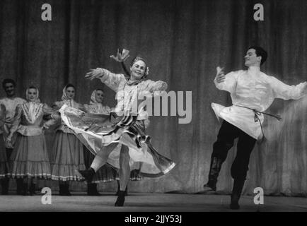 Assomiglia a due bambole, una ballerina russa bionda con coda di maiale e la sua compagna una danza tradizionale in costume attivo. Ci sono 10 uomini e donne in azienda. Dicembre 10, 1955. (Foto di Roger Wood). Foto Stock