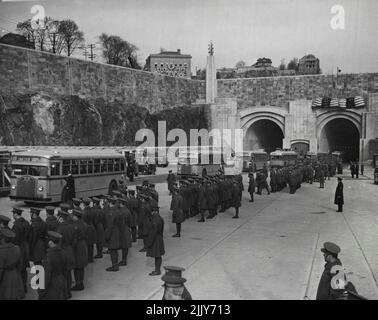 Parade apre New Manhattan Gateway -- Ecco una sfilata di autobus che emergono dal nuovo Lincoln Tunnel che collega il New Jersey con la città centrale di New York City come cerimonie di dedica per la metropolitana sud si sono tenute Dicembre 21. Qui è mostrato il portale Jersey del nuovo percorso veicolare di Subhudson. Le truppe sono allineate lungo la strada mentre gli autobus che trasportavano gli autobus che trasportavano 1.500 attraverso il tunnel emergono. Dicembre 21, 1937. (Foto di stampa associata). Foto Stock