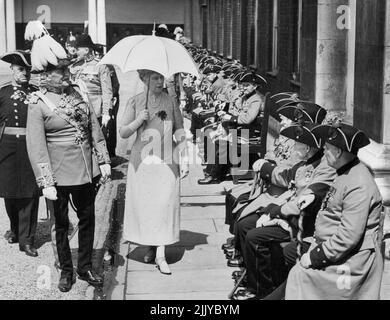 La Regina Maria ispeziona i pensionati anziani del Chelsea -- la Regina Maria, accompagnata dal Gen. Sir Walter Braithwaite, governante dell'Ospedale, parlando con i pensionati veterani del Chelsea. La Regina Maria ha fatto una visita inaspettata al Chelsea Royal Hospital questa mattina, e ha partecipato alla sfilata ' Oak Apple Day ', in commemorazione della fondazione dell'Ospedale da parte di re Carlo II. Maggio 29, 1937. (Foto di Keystone). Foto Stock