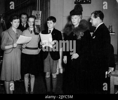 Il 25th marzo 1943, la Regina Maria ha fatto una visita alla Broadcasting House di Bristol, dove ha visto una trasmissione delle scuole, e ha partecipato a una prova dell'Orchestra di Ivy Benson e dell'ora dei bambini. Regina Mary con Derek McCulloch, alle prove per bambini dell'ora del gioco di Elizabeth Nesbit ' The Railway Children ' - giovani giocatori che leggono da sinistra a destra Rosamund Barnes, Jill Andrews, Peter Pullen - con Charles Mason in background. Agosto 09, 1943. (Foto della BBC). Foto Stock