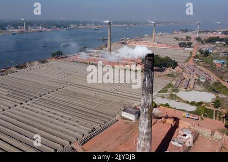 28 luglio 2022, Dhaka, Dhaka, Bangladesh: Vista aerea del fumo che versa dalla pila di camino di forni di mattoni a Dhaka, Bangladesh. I forni a mattone sono responsabili del 17% delle emissioni annue di anidride carbonica (CO2) e del 58% dell'inquinamento atmosferico della città di Dhaka. Ci sono circa 5000 forni di mattoni gestiti privatamente all'interno del Bangladesh, di cui 1000 intorno alla capitale, Dhaka. Con i suoi 160 milioni di abitanti, il Bangladesh è un paese in costante domanda di mattoni come materiale primario per la costruzione di edifici nell'era dell'urbanizzazione. Forni di mattone liberano sopra 1.072 milione tonnellate di Foto Stock