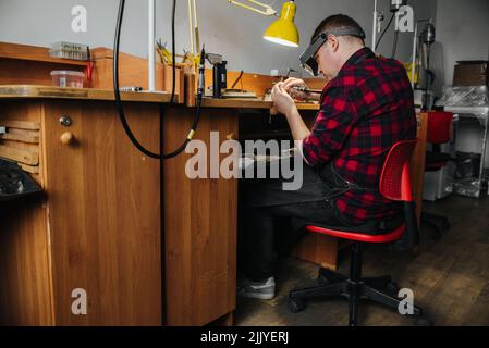 un gioielliere lavora con un pezzo di gioielleria Foto Stock