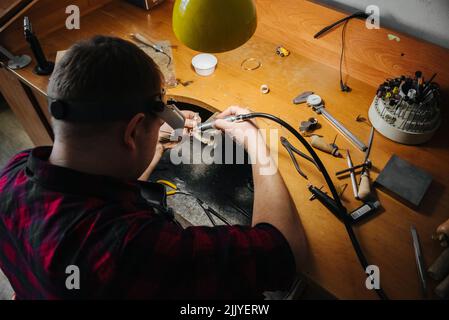 un gioielliere lavora con un pezzo di gioielleria Foto Stock