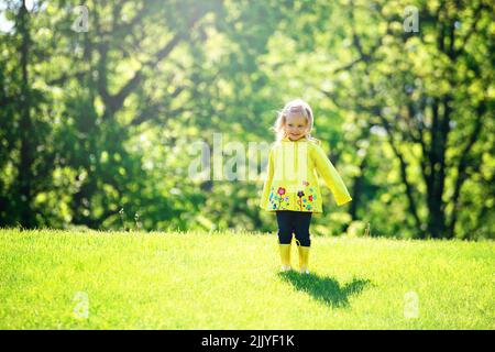 Bambina bionda in impermeabile giallo. Foto Stock