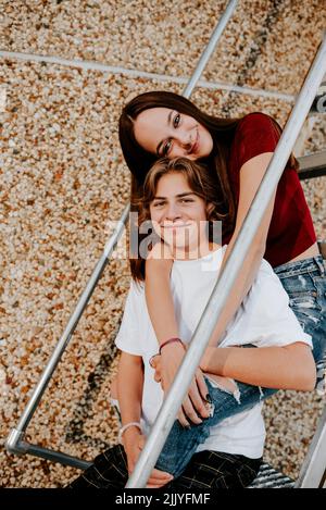 felice ragazzo sorridente e ragazza adolescente seduto sulle scale Foto Stock