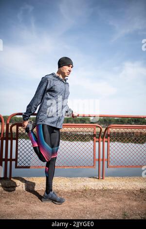 L'uomo runner allunga la gamba dopo l'allenarsi Foto Stock