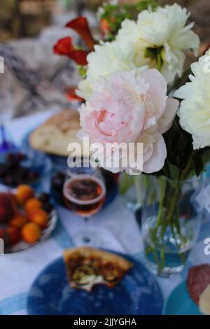 bel pic-nic con fiori pizza e vino Foto Stock