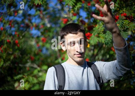 Il ragazzo sullo sfondo di bacche rosse. Foto Stock