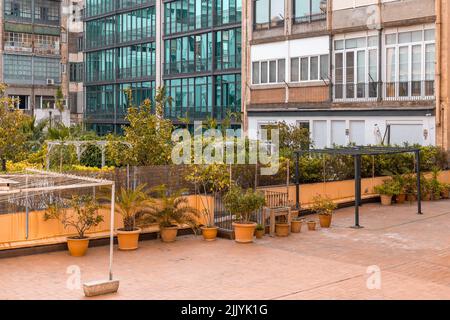 patio o cortile tra gli edifici di appartamenti a Barcellona, Spagna. Impianti in pentole di ceramica e costruzione metallica per asciugare i vestiti Foto Stock