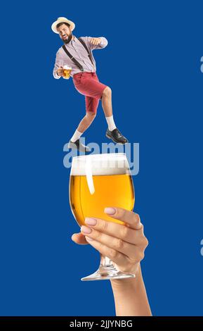 Collage con mano che tiene un bicchiere di birra e un piccolo uomo in abiti tradizionali tedeschi su sfondo blu. Celebrazione dell'ottobre Foto Stock