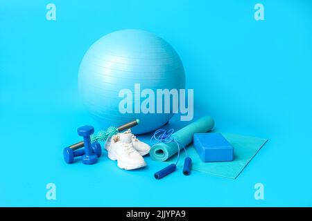 Set di attrezzature sportive e scarpe su sfondo blu Foto Stock