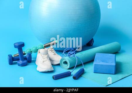 Set di attrezzature sportive e scarpe su sfondo blu Foto Stock