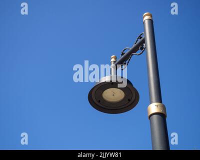 Lanterna nera contro il cielo blu. Design della lampada interessante. Illuminazione stradale. OFF lanterna Foto Stock