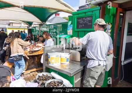 I clienti che acquistano pesce fresco e crostacei al porto di Oban, cozze, granchi, aragoste tutti in vendita e cozze cotte in aglio,Oban,Highlands,Scozia, Foto Stock