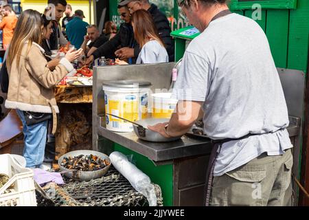 I clienti che acquistano pesce fresco e crostacei al porto di Oban, cozze, granchi, aragoste tutti in vendita e cozze cotte in aglio,Oban,Highlands,Scozia, Foto Stock