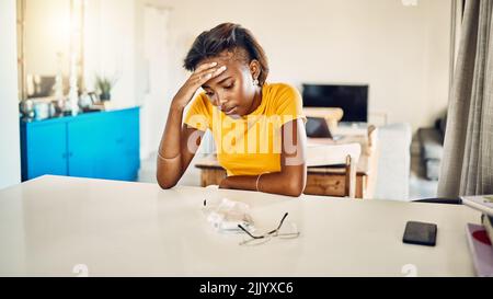 Stressato, stanco e frustrato studente africano seduto nella sua stanza pensando a problemi stressanti. Depressa, ansiosa ed esausta femmina preoccupata Foto Stock