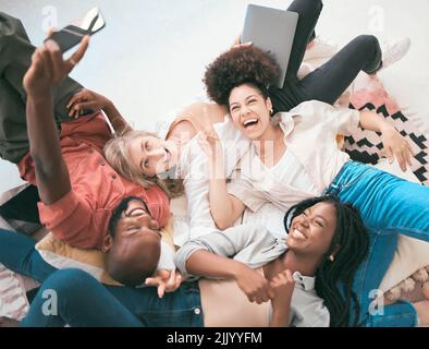 Il team creativo e eccitato utilizza un telefono per un selfie mentre ti rilassi, ti godi il lavoro e ti diverti. Un gruppo diversificato di colleghi di lavoro che mostrano il lavoro di squadra Foto Stock