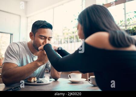 Romantico, in amore e affettuoso datazione coppia insieme su una data in un caffè o ristorante. Bello, cura e amore ragazzo giovane baciare e. Foto Stock