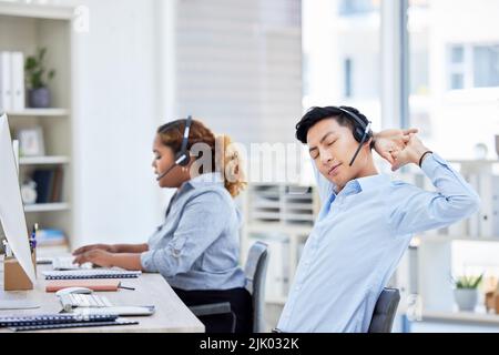 Stretching, stressato e stanco agente di call center che soffre di burnout, mal di schiena o di essere sovraccaricato. Servizio clienti pigro, annoiato e esausto Foto Stock