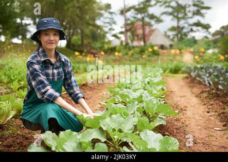 Ritratto di giovane ragazza asiatica allegra che lavora in giardino Foto Stock