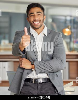 Theres non è mai stato un momento migliore per essere voi. Ritratto di un giovane uomo d'affari che mostra i pollici in un ufficio moderno. Foto Stock
