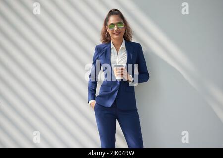Ritratto di sorridente donna di successo con cupe di take-out caffè Foto Stock
