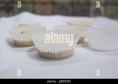 Versare l'impasto del muffin negli stampi Foto Stock