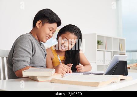 Fratello e sorella vietnamita che fanno i compiti insieme Foto Stock