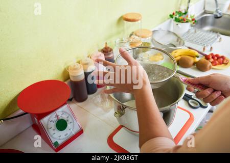 Preparare la farina setacciata quando si fa l'impasto per la torta Foto Stock