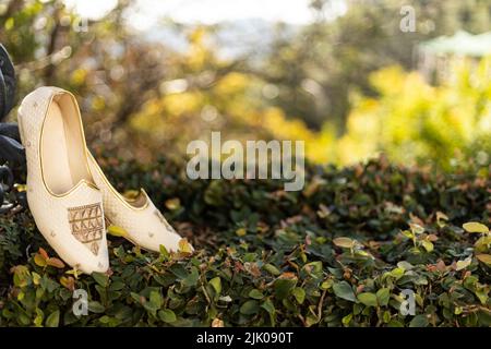 Sposi sandali tradizionali beige da sposa. Calzature eleganti e glamour. Bellissimo paio di scarpe da uomo su erba, foto di primo piano di alta qualità Foto Stock