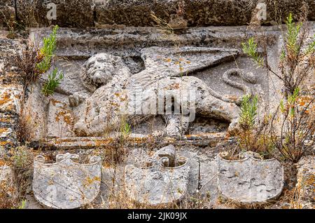 antica cresta araldica gettata in pietra sopra la porta di un antico edificio greco, cresta araldica scolpita in pietra piena, cresta storica in pietra Foto Stock