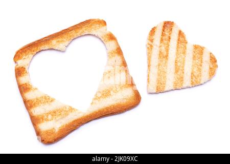 Pane tostato con segni del grill e foro a forma di cuore isolato su sfondo bianco Foto Stock