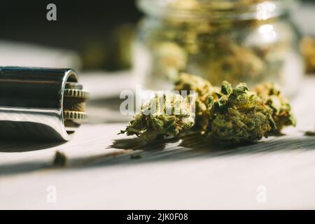 Primo piano di marijuana medica o germogli di fiori di cannabis e accendino. Foto Stock