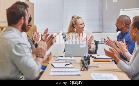 Un gruppo di imprenditori che plaudono durante una riunione nella sala del consiglio d'amministrazione. Foto Stock