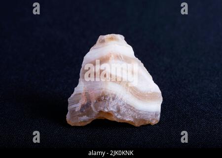 Agata a bande scure. Agate è una formazione rocciosa comune, costituita da calcedonia e quarzo come suoi componenti primari, con un'ampia varietà di colori. Foto Stock