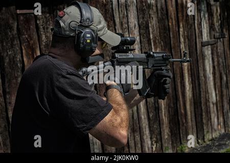 Un uomo sparatutto al poligono di tiro allenarsi con la pistola Foto Stock