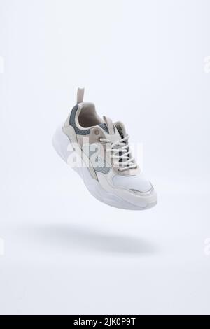 Bianco con colori Athletic Sports Shoes sospeso in aria con sfondo bianco Foto Stock