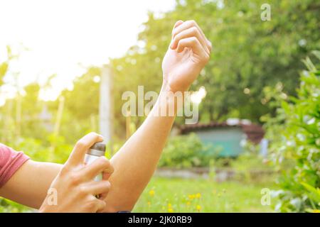 Giovane uomo spruzzando repellente contro qualche tipo di insetti, concetto di assistenza sanitaria Foto Stock