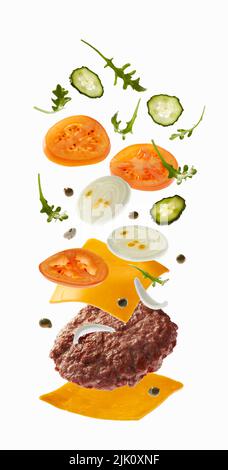 Hamburger con ingredienti volanti su sfondo bianco Foto Stock