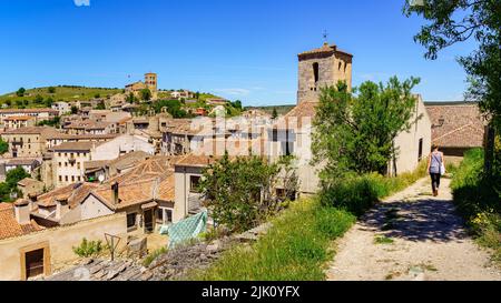 Donna da dietro camminando lungo il sentiero accanto alla città vecchia medievale. Sepulveda Segovia Spagna. Foto Stock