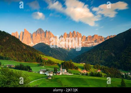 Tramonto sulle vette delle Odle e sul villaggio alpino di Santa Magdalena in primavera, Val di Funes, Alto Adige, Italia, Europa Foto Stock