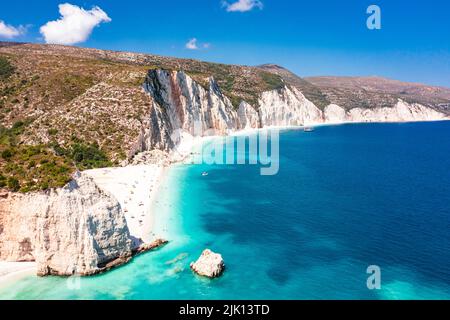 I turisti prendono il sole presso l'idilliaca spiaggia di Fteri, adagiato tra scogliere e laguna blu, vista dall'alto, Cefalonia, Isole IONIE, Isole Greche, Grecia, Europa Foto Stock