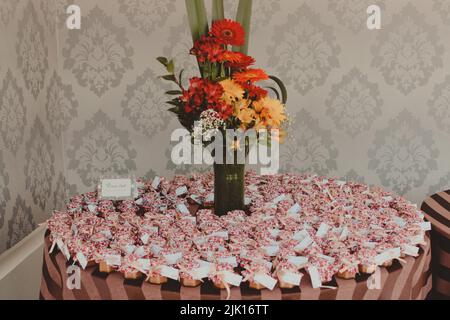 tavolo con disposizione dei fiori e favori per matrimoni Foto Stock