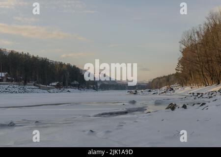 Fiume Katun nella Repubblica di Altai, Russia. Parzialmente congelato in inverno. Montagne sullo sfondo. Foto Stock